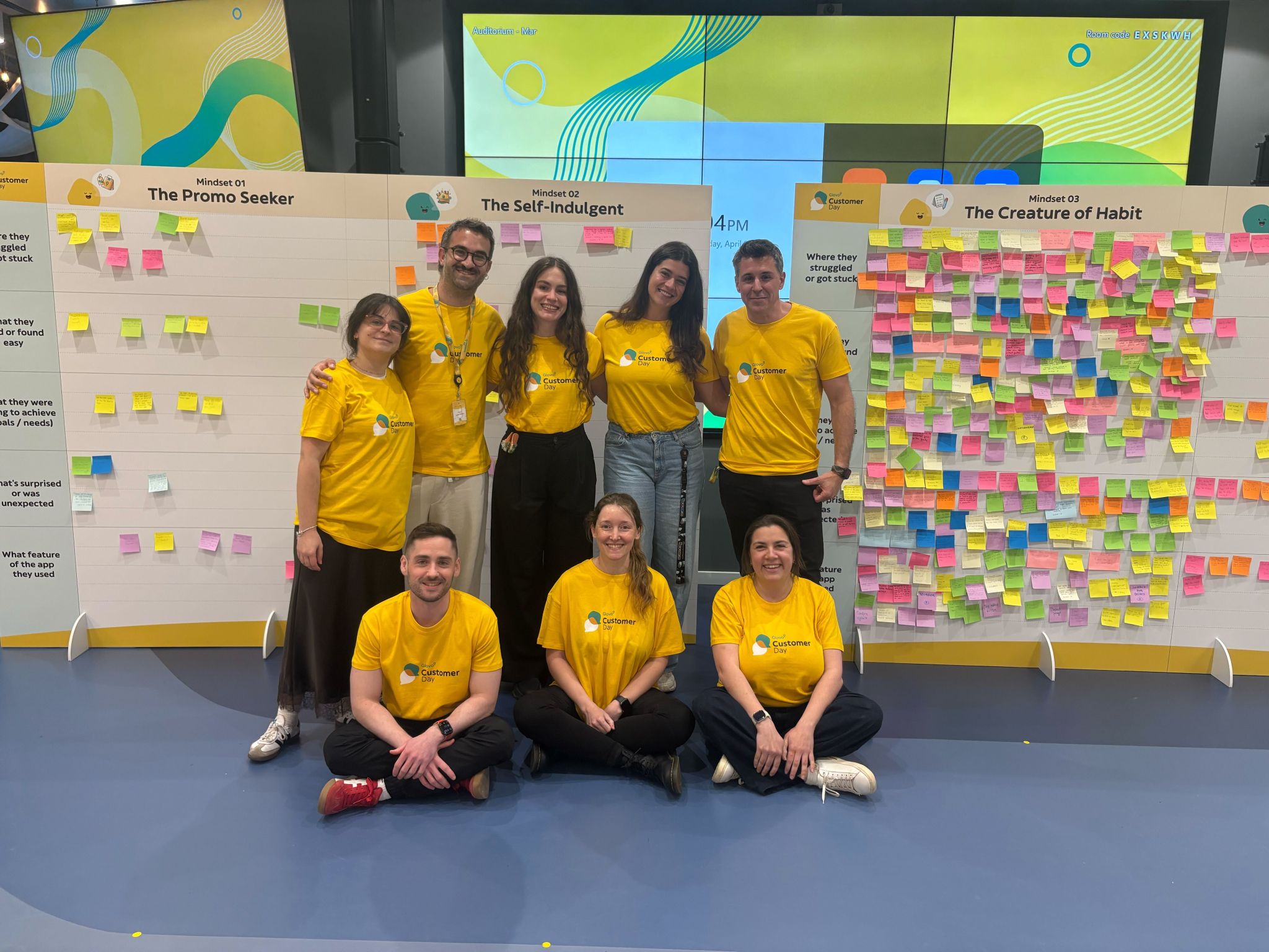 Glovo team in front of the completed mindset walls at Customer Day